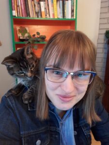 Janice Winkler sits with a cat on her shoulders